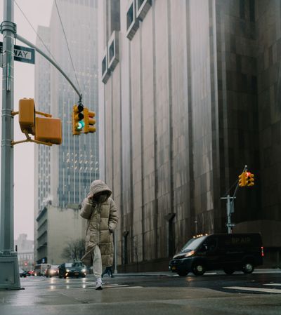 Tribecca woman during rain in front of a brutalist building